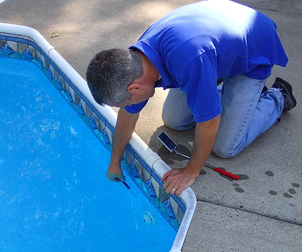 A pool technician repairing a pool surface.