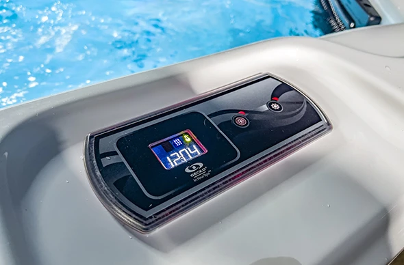 A close-up view of a spa control panel on the edge of a hot tub.